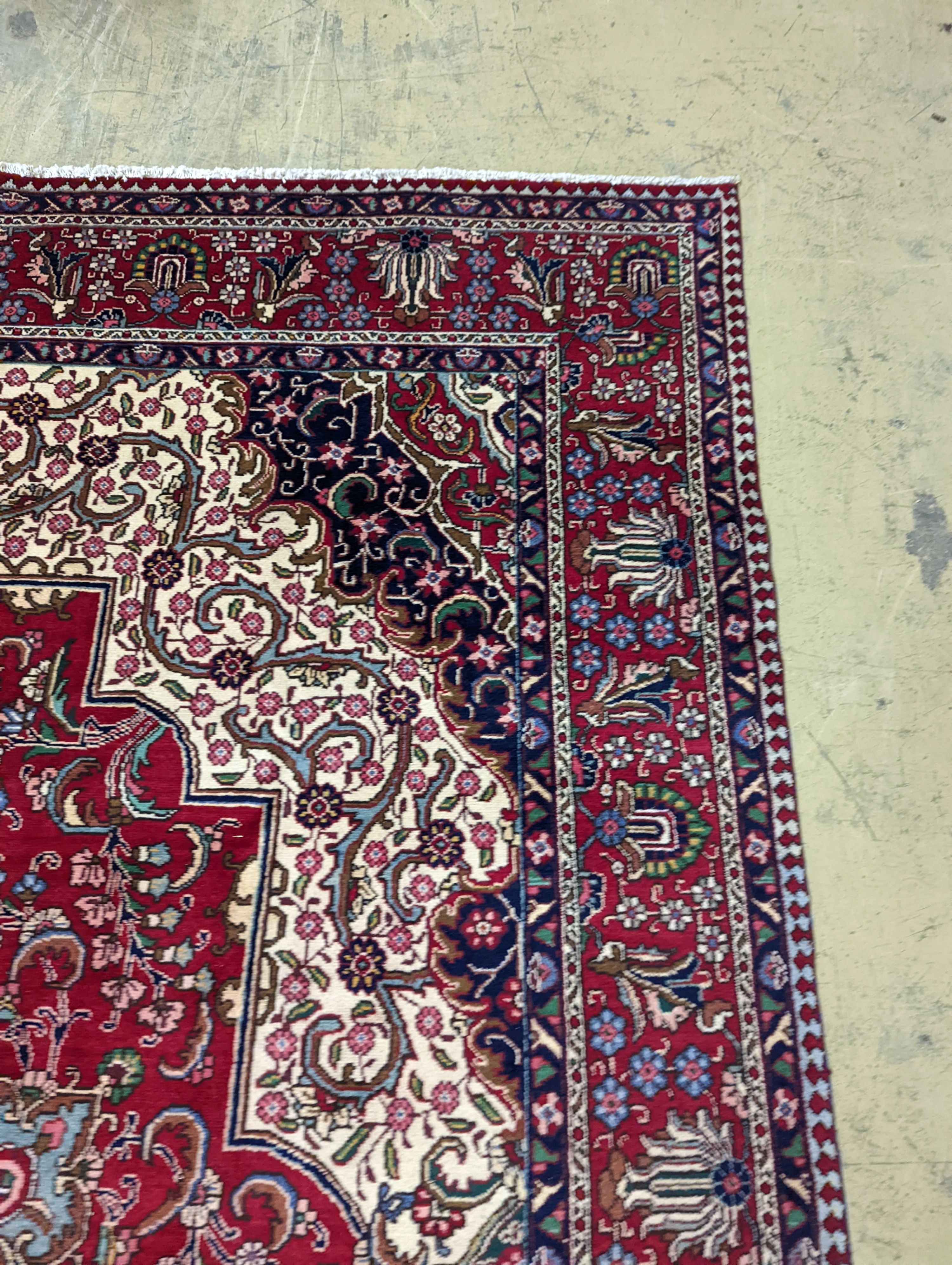 A Tabriz red ground carpet, 405 x 292cm